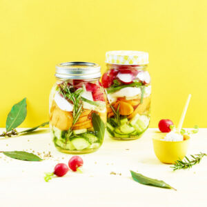 bocaux de legumes lacto-fermentes par un photographe culinaire, arriere plan jaune