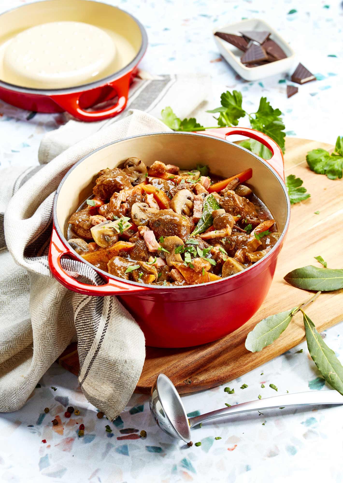 photographie culinaire d'une cocotte de boeuf bourguignon avec carottes et champignons, pour l'édition