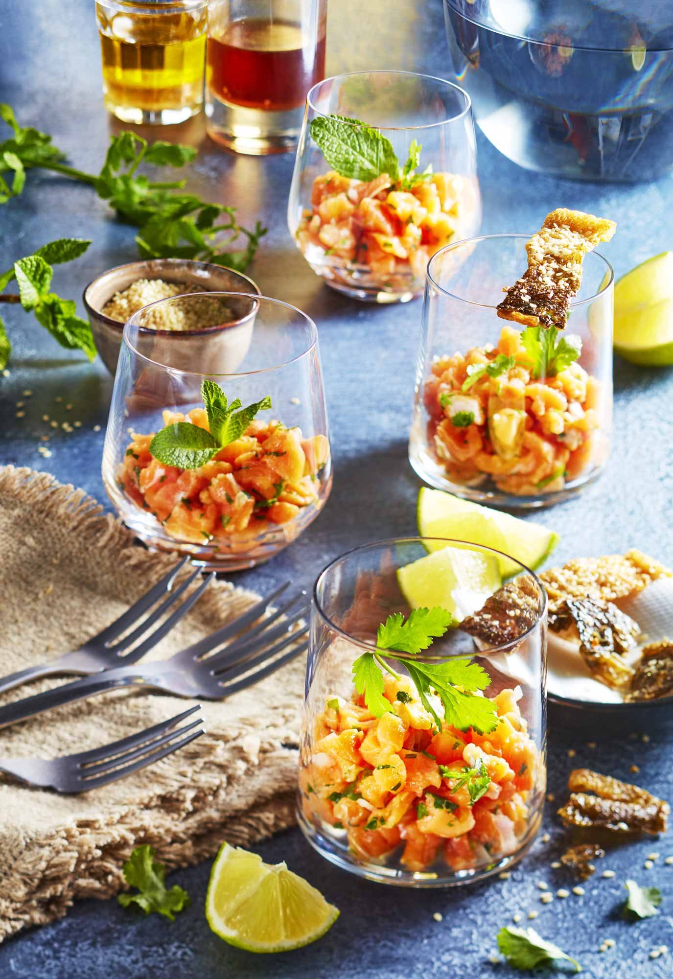 verrines de tartare de saumon, peau grillée, menthe et citron, plan de travail bleu