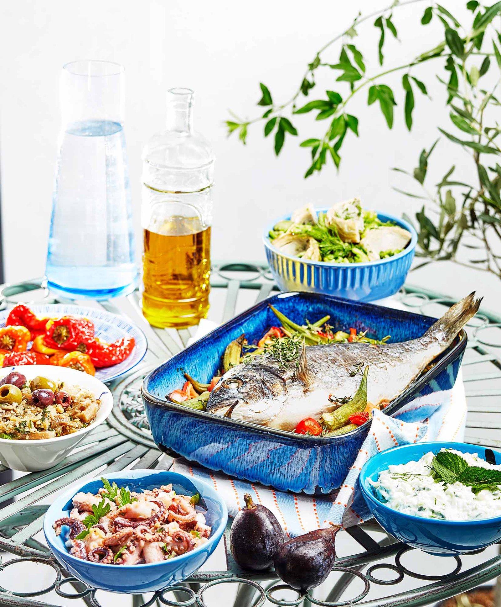 table avec plats crétois variés, dorade aux gombos au four, salade de calamar, tzatziki, poivrons grillés...