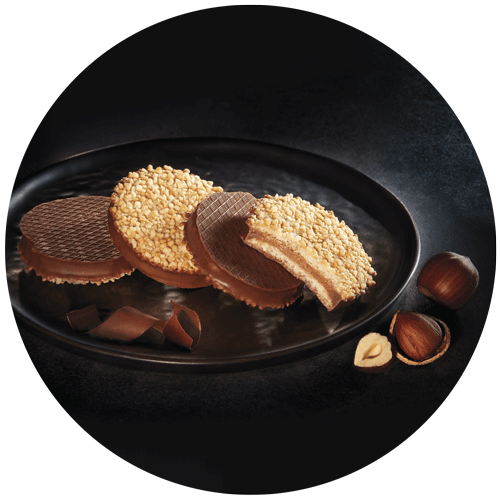 biscuits meringués au chocolat dans une assiette noir à bord haut et noisettes, pris par un photographe culinaire packaging
