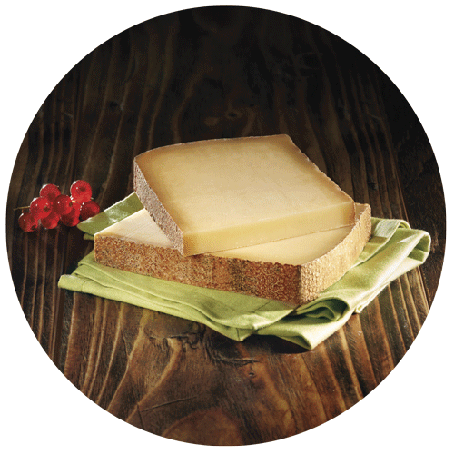 tranches de comté superposées sur une serviette verte avec des groseilles pour figurer sur un emballage de fromage