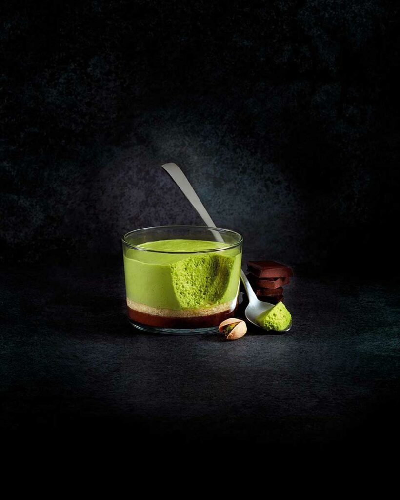 photo culinaire en clair obscur de royal à la pistache entamé