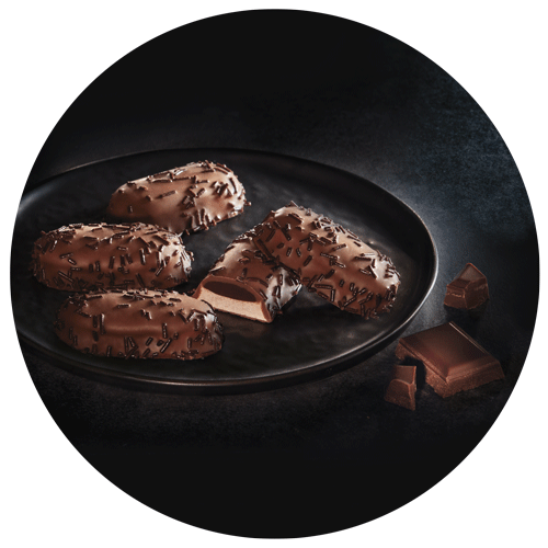 biscuits meringués au chocolat dans une assiette noire et carrés de chocolat pour illustrer l'emballage de ces biscuits